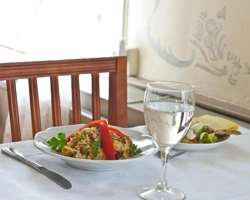 Vit servett och vinglas på dukat bord i restaurangen